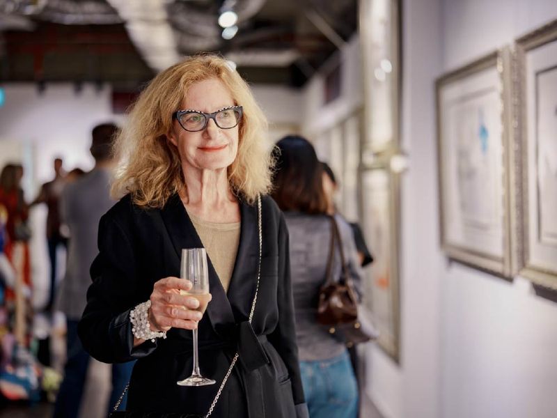 A guest with a glass of champagne at a VANTA art evening
