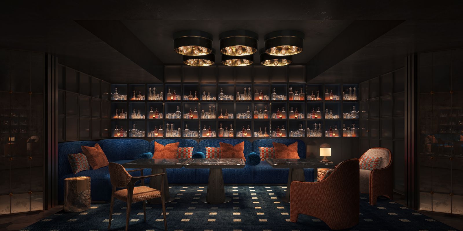 The members' spirits library at VANTA, a lit wall of bottles behind a blue velvet banquette